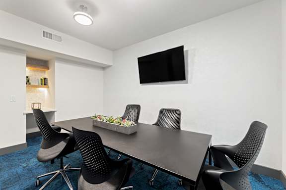 A conference room with a long table and chairs.