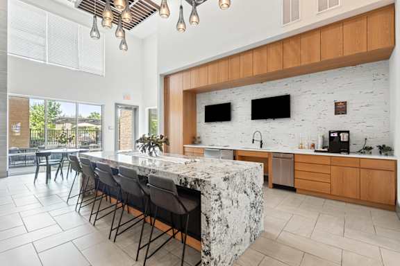 A kitchen with a marble island and wooden cabinets.