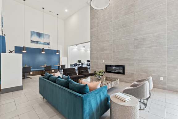A living room with a blue couch and a fireplace.