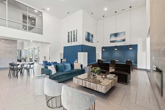 A modern living room with a blue accent wall and a coffee table in the center.