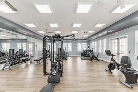 A spacious gym with a variety of equipment including treadmills, weights, and exercise machines.