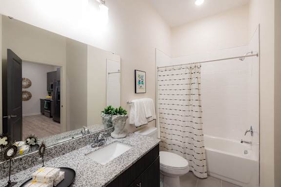 A bathroom with a white shower curtain and a white toilet at Hudson at Renaissance Apartments, Wilmington 28405