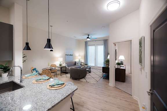 A modern kitchen with granite countertops and pendant lights at Hudson at Renaissance Apartments, North Carolina