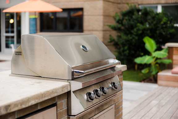A stainless steel grill is on a patio at Hudson at Renaissance Apartments, Wilmington 28405