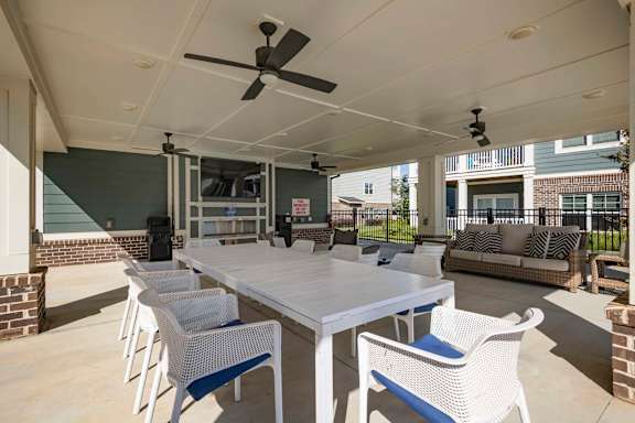 A patio with a white table and chairs and a ceiling fan at Waterleaf at Neely Ferry Apartments, South Carolina 29680
