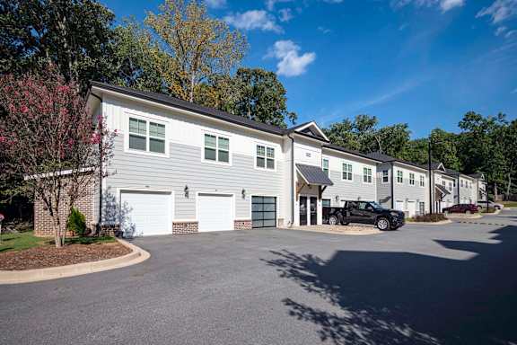 A row of houses with a car parked in front of them at Waterleaf at Neely Ferry Apartments, Simpsonville, SC