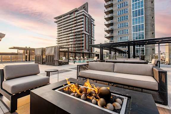 A modern outdoor seating area with a fire pit in the center.