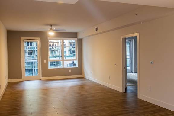A room with wooden floors and a window overlooking a cityscape.