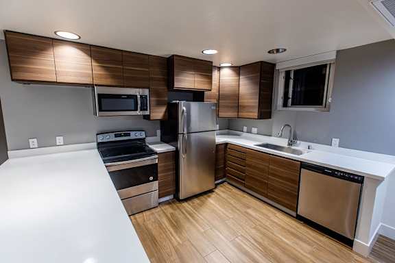 A modern kitchen with stainless steel appliances and wooden cabinets.