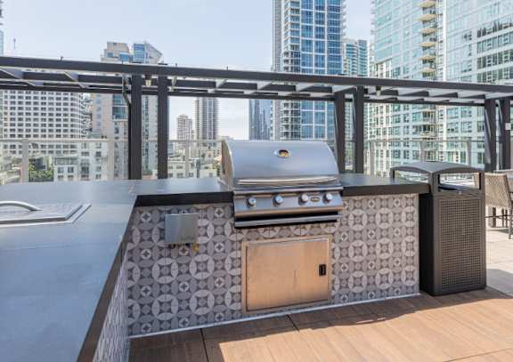 A modern outdoor kitchen with a grill and a table.