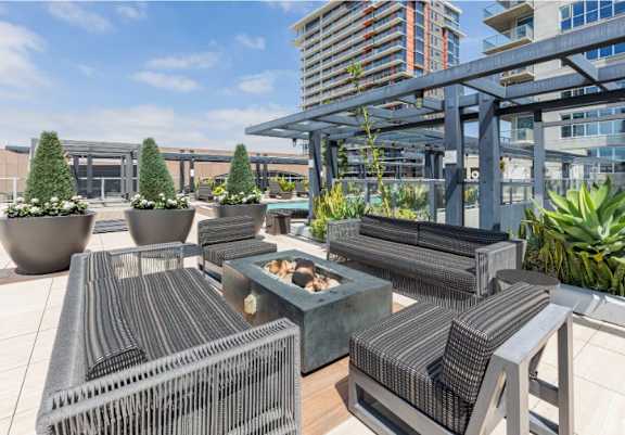 A patio with a table and chairs and a building in the background.