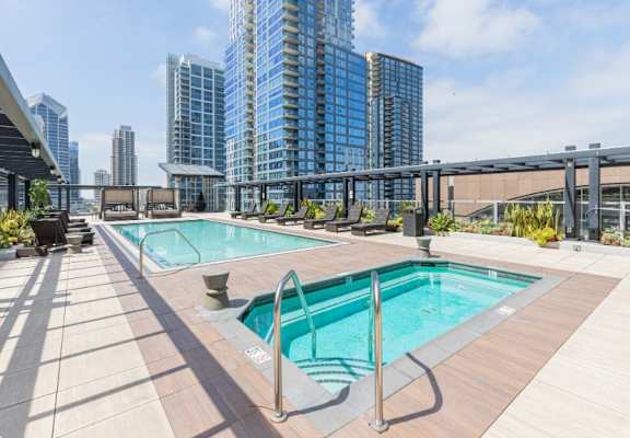 A swimming pool on a rooftop with a cityscape in the background.