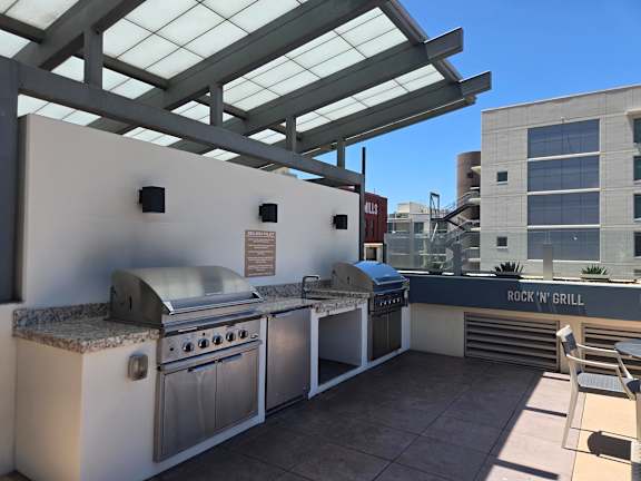 A patio with a grill and a table.