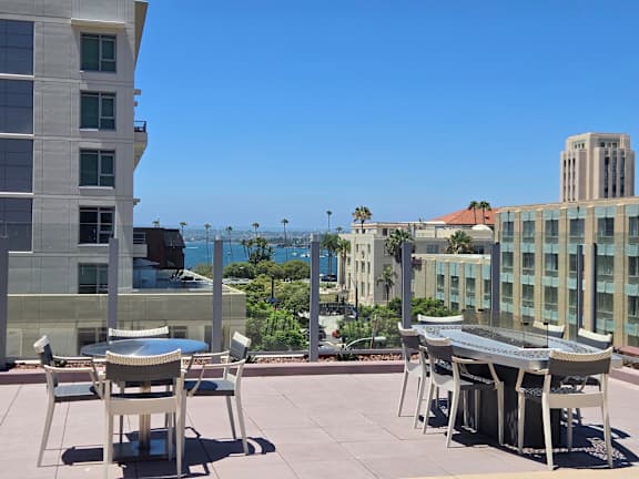A patio with a table and chairs overlooks a cityscape.