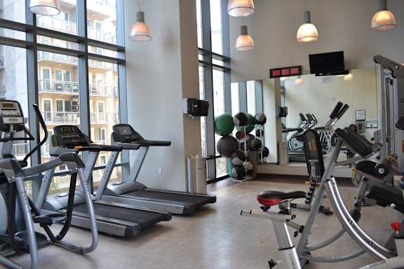 A gym with treadmills, elliptical machines, and other exercise equipment.