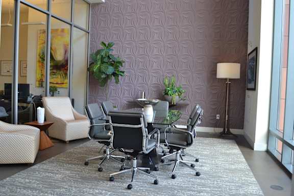 A conference room with a purple patterned wall and a grey carpet.