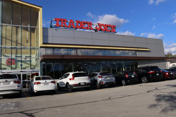 a trader joes parking lot full of cars in front of a building