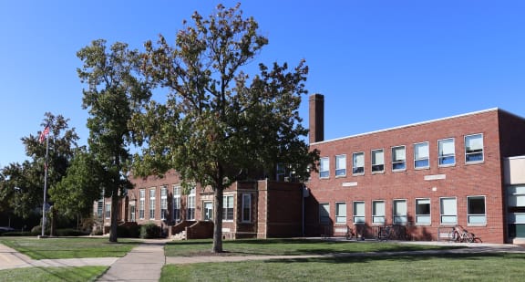 a red brick building with a tree in front of it