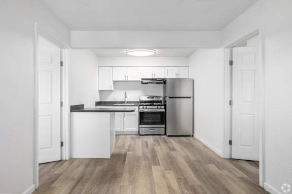A kitchen with white cabinets and stainless steel appliances.