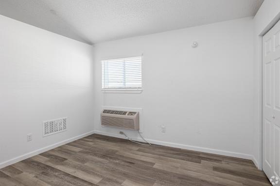 A room with a window and a wall-mounted air conditioner.