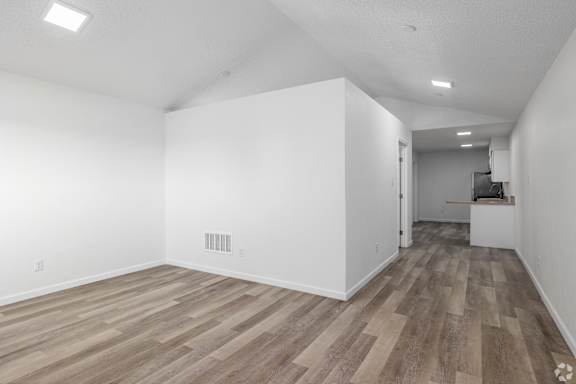 A room with wooden flooring and white walls.