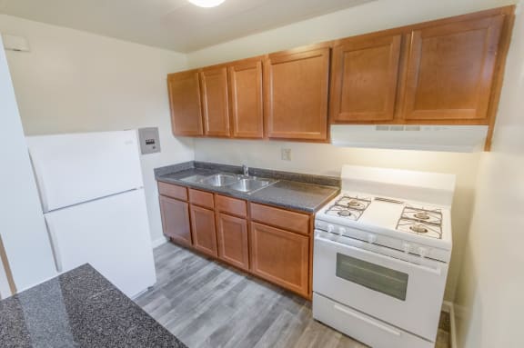 This is a photo of the kitchen of the 550 square foot 1 bedroom, balcony floor plan model apartment at College Woods Apartments in Cincinnati, OH.
