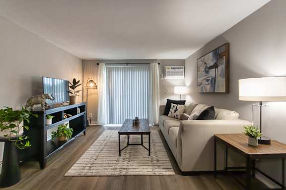 A modern living room with a large sofa, a coffee table, and a TV in a 1 bedroom, 1 bath 560 square foot apartment at Aspen Village Apartments in the Westwood neighborhood of Cincinnati, OH.