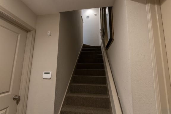 This is a photo of the entryway stairs to the second floor and the door to the attached, direct-access garagein the 826 square foot 1 bedroom , 1 bath apartment at The Brownstones Townhome Apartments in Dallas, TX.