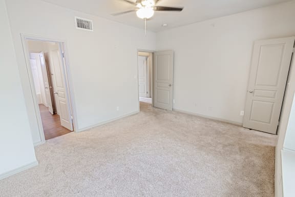 This is a picture of the primarybedroom in the 1320 square foot 2 bedroom, 2 and 1/2 bath floor plan at The Brownstones Townhome Apartments in Dallas, TX..