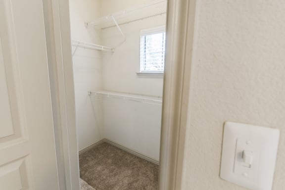 This is a picture of the primary bedroom walk-in closet in the 1320 square foot 2 bedroom, 2 and 1/2 bath floor plan at The Brownstones Townhome Apartments in Dallas, TX..