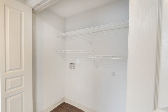 This is a picture of the utility closet with washer and dryer connections in the 1320 square foot 2 bedroom, 2 and 1/2 bath floor plan at The Brownstones Townhome Apartments in Dallas, TX..
