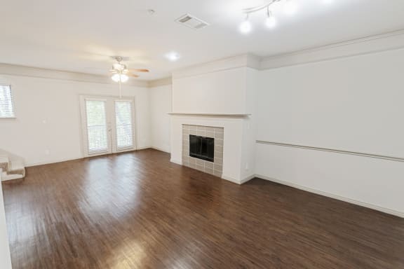 This is a picture of the living room and dining area of the 1320 square foot 2 bedroom, 2 and 1/2 bath floor plan at The Brownstones Townhome Apartments in Dallas, TX..