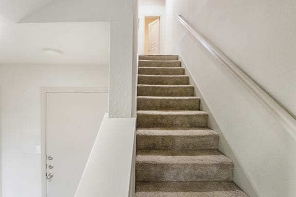 This is a picture of the stairs to the second floor of the 1320 square foot 2 bedroom, 2 and 1/2 bath floor plan at The Brownstones Townhome Apartments in Dallas, TX..