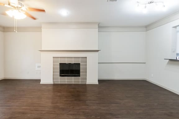This is a picture of the living room and dining area of the 1320 square foot 2 bedroom, 2 and 1/2 bath floor plan at The Brownstones Townhome Apartments in Dallas, TX..