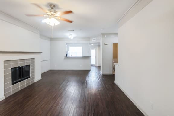 This is a picture of the living room and dining area of the 1320 square foot 2 bedroom, 2 and 1/2 bath floor plan at The Brownstones Townhome Apartments in Dallas, TX..