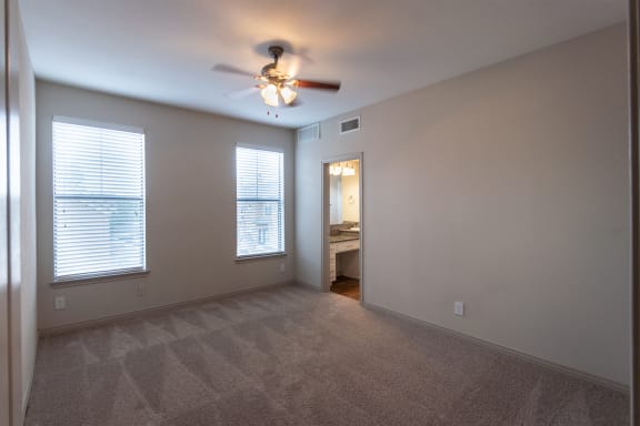 This is a photo of the primary bedroom of the 1486 square foot 3 bedroom, 3 bath floor plan at The Brownstones Townhome Apartments in Dallas, TX.