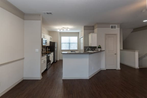 This is a photo of the kitchen from the dining area of the 1486 square foot 3 bedroom, 3 bath floor plan at The Brownstones Townhome Apartments in Dallas, TX.