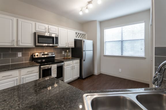 This is a photo of the kitchen of the 1486 square foot 3 bedroom, 3 bath floor plan at The Brownstones Townhome Apartments in Dallas, TX.