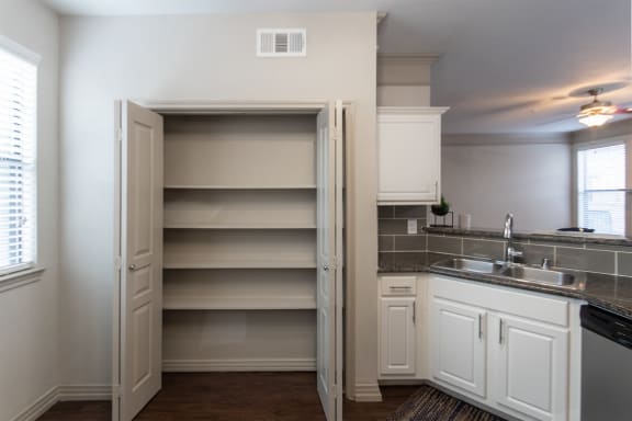 This is a photo of the pantry in the kitchen of the 1486 square foot 3 bedroom, 3 bath floor plan at The Brownstones Townhome Apartments in Dallas, TX.