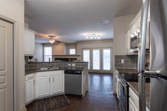 This is a photo of the kitchen of the 1486 square foot 3 bedroom, 3 bath floor plan at The Brownstones Townhome Apartments in Dallas, TX.