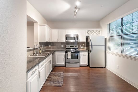 This is a photo of the kitchen of the 1661 square foot 3 bedroom, 3 and a half bath floor plan at The Brownstones Townhome Apartments in Dallas, TX.