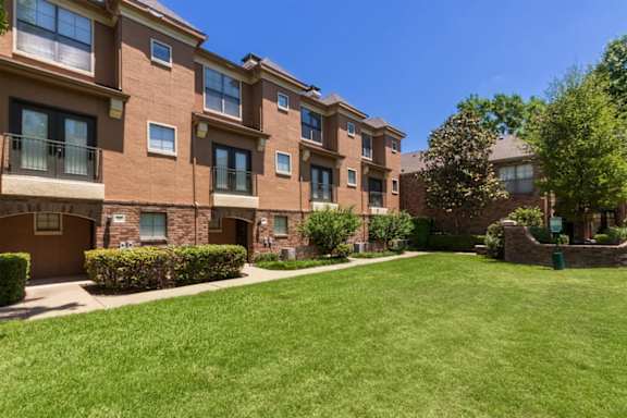 This is a photo of the building exteriors/the courtyard at The Brownstones Townhome Apartments in Dallas, TX.