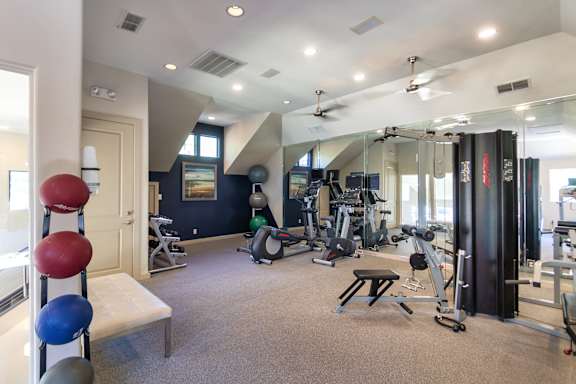 The 24-hour fitness center with a variety of equipment including free weights and cardio machines. at The Brownstones Townhome Apartments in the Far North Dallas neighborhood of Dallas, TX.