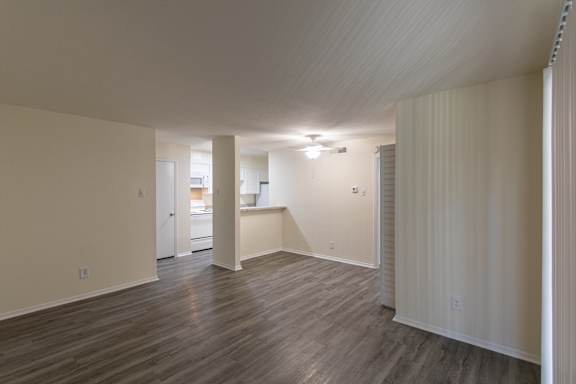 View of the dining area and kitchen with white cabinets and appliances in a 1 bedroom, 1 bath 752 sq ft apartment home with hardwoodlike flooring throughout at The Biltmore Apartments located in the Vickery Midtown neighborhood of Dallas, TX.