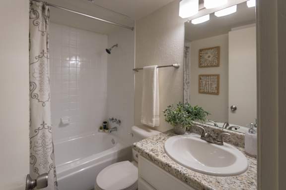A bathroom with a white vanity in a 1 bedroom, 1 bath 554 sq ft apartment home at The Biltmore Apartments located in the Vickery Midtown neighborhood of Dallas, TX.