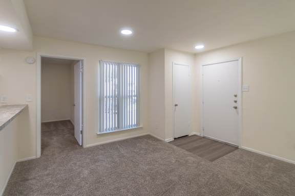 Dining area with a view of the kitchen pass-through window  and entryway in a 2 bedroom, 1.5 bath 846 sq ft apartment home at The Biltmore Apartments located in the Vickery Midtown neighborhood of Dallas, TX.