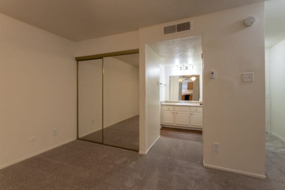 This is a photo of the mirrored closet doors in the living room in the 450 square foot efficiency apartment at Cambridge Court Apartments in Dallas, TX.