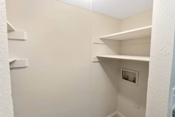 Closet with washer and dryer connections in the 982 square foot 1 bedroom, 1 bath apartment at Cambridge Court Apartments in Dallas, TX.