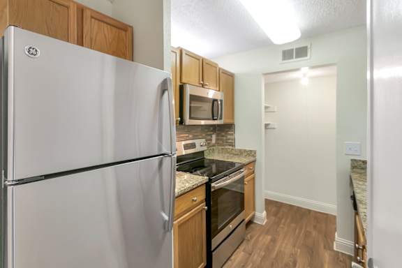 Kitchen with granite countertops in the 982 square foot 1 bedroom, 1 bath apartment at Cambridge Court Apartments in Dallas, TX.