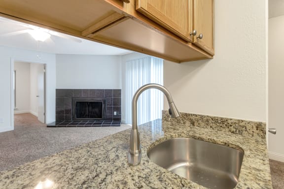 This is a photo of the living room from the kitchen of the 982 square foot 1 bedroom, 1 bath apartment at Cambridge Court Apartments in Dallas, TX.